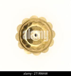 top view of a flower shaped vintage brass door knob part in gold isolated on white background Stock Photo