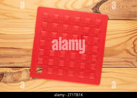One silicone pot holder, macro, on a wooden table, top view. Stock Photo