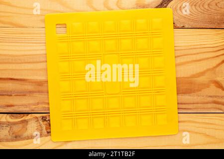 One silicone pot holder, macro, on a wooden table, top view. Stock Photo