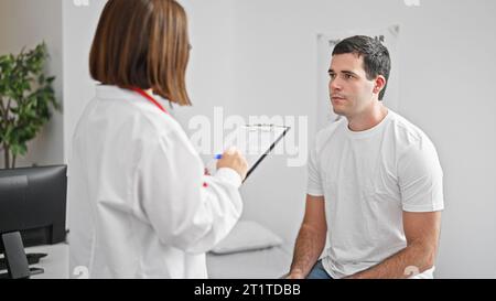 Doctor and patient having medical consultation taking notes at the clinic Stock Photo
