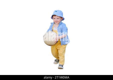 The child's happiness is evident as they run after the ball on the sports field, isolated on white background. Baby is happily playing with the white Stock Photo