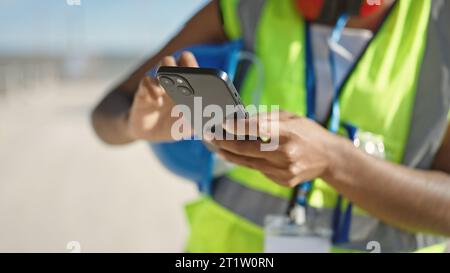 African american woman builder using smartphone at street Stock Photo