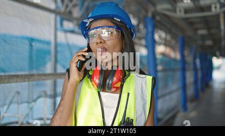 African american woman builder talking on smartphone at street Stock Photo