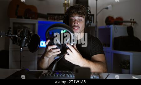 Handsome hispanic man caught in thrilling night-time gaming stream, engrossed in virtual conversation amidst the glow of his gaming room, headphones r Stock Photo
