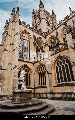 View of statuette and part of Bath Abbey. The abbey is constructed of Bath stone, and was rebuilt in the 12th and 16th centuries. Stock Photo