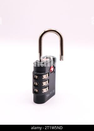 A blacked unlocked lock standing against a black background Stock Photo