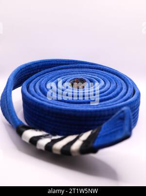A rolled up brazilian jiu jitsu ranking belt blue with four stripes Stock Photo