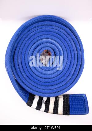 A rolled up brazilian jiu jitsu ranking belt blue with four stripes Stock Photo