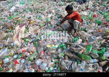 Dhaka, Bangladesh. 15th Oct, 2023. Employees recycling empty pet bottles to be reused again in a plastic bottle recycling factory. On October 15, 2023 in Dhaka, Bangladesh.Almost all juice, beverage and drinking water products are packaged in plastic bottles. These bottles are collected from streets, shops and homes. Photo by Habibur Rahman/ABACAPRESS.COM Credit: Abaca Press/Alamy Live News Stock Photo