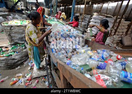 Dhaka, Bangladesh. 15th Oct, 2023. Employees recycling empty pet bottles to be reused again in a plastic bottle recycling factory. On October 15, 2023 in Dhaka, Bangladesh.Almost all juice, beverage and drinking water products are packaged in plastic bottles. These bottles are collected from streets, shops and homes. Photo by Habibur Rahman/ABACAPRESS.COM Credit: Abaca Press/Alamy Live News Stock Photo