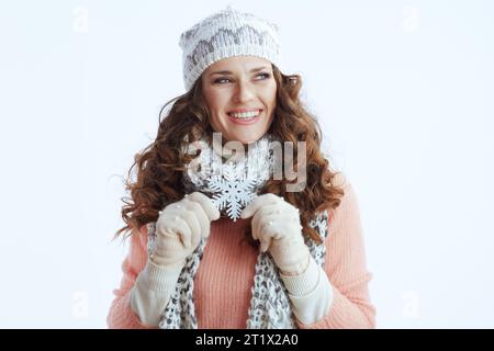 Hello winter. happy trendy middle aged woman in sweater, mittens, hat and scarf isolated on white background with snowflake. Stock Photo