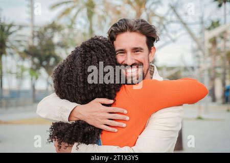 Happy adult man hugging his female best friend after long time without seeing each other. Thankful boyfriend embracing and giving a tender and affectionate greeting to his girlfriend. Young couple. High quality photo Stock Photo