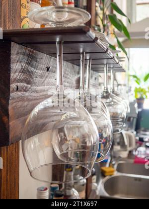 Glasses hang over the bar counter. The glasses are turned upside down. restaurant interior. Concept of drinking alcoholic beverages. Glass glasses for Stock Photo