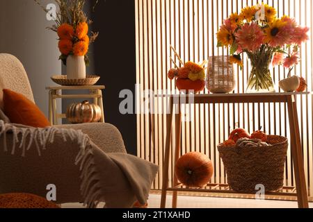 Room decorated with pumpkins and bright flowers. Autumn vibes Stock Photo