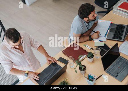 Business Employees in a Modern Multiracial Office Using Technology for Better Efficiency Stock Photo