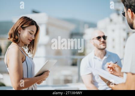 A collaboration of architects and engineers working on a modern urban building design outdoors. Stock Photo