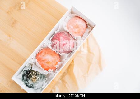 Delicious colored mochi in a box on a wooden board Stock Photo