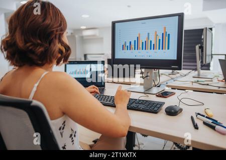 In a diverse office, confident female professional analyze data, plan strategies, and use technology for business success. Stock Photo