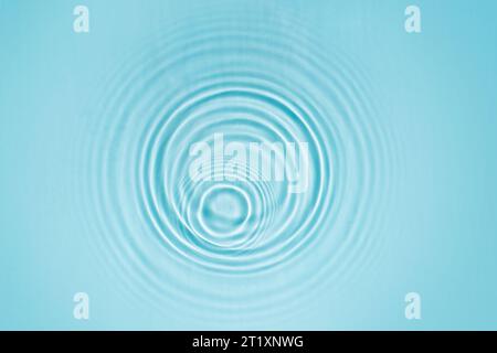 Raindrops on the surface of the water. Swimming pool water background with drops and ripples from rain. Abstract natural backdrop Stock Photo