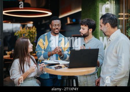 Multiracial business team collaborates on projects, discussing ideas and sharing knowledge for efficient work outcomes. Stock Photo