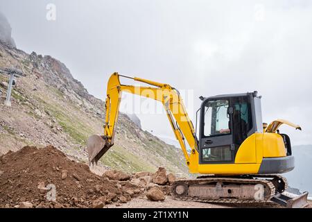 Excavator works in the highlands. Makes a trench for communications ...
