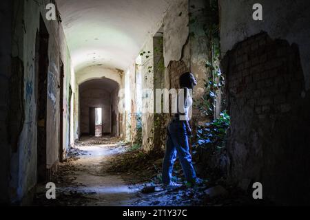 A female model poses inside the ruins of a Soviet-era military base in Szombatheley, Hungary. Stock Photo