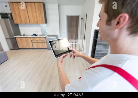 Worker with tablet computer checking alarm system indoors. Stock Photo