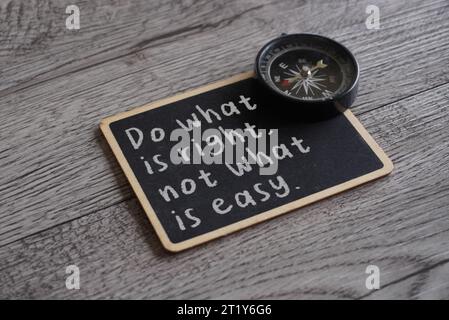 Closeup image of chalkboard with text DO WHAT IS RIGHT, NOT WHAT IS EASY and compass. Moral compass concept Stock Photo