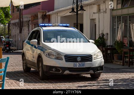 Mohos, Lasithi district, Crete, Greece.  30.09.2023.  Greek police car on blue light driving through small town on narrow street. Stock Photo