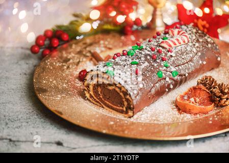 Traditional Christmas cake. Chocolate yule log with christmas decoration on a grey board. Christmas dessert conceptt Stock Photo