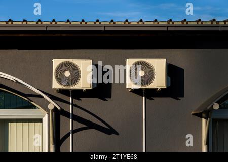 Air conditioner external units mounted on building wall. Heat pumps air to air equipment on facade. Stock Photo