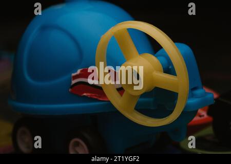 A blue plastic helicopter toy with a yellow propeller at the back under macro photography Stock Photo