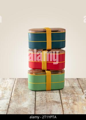 colored lunch boxes stand on a wooden table Stock Photo