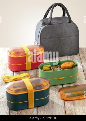 colored lunch boxes stand on a wooden table Stock Photo