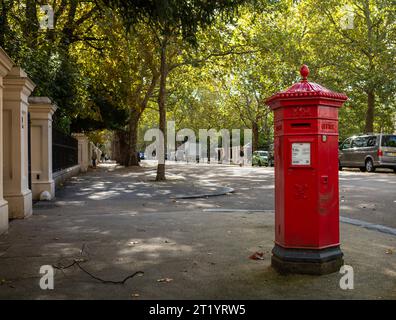 A hexagonal Victorian-era red post box known as a 'Penfold' first introduced in 1866 and still in use in Kensington Palace Gardens, London, UK.  It wa Stock Photo