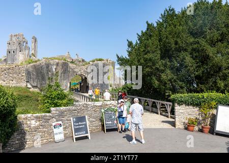 Corfe Castle in Devon England, visitors to the castle head towards the entrance arch on a sunny autumn day 2023, historic castle ruins,England,UK Stock Photo