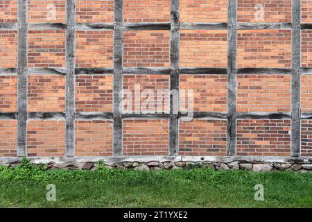Old brick wall and green grass. Background and texture for design. Stock Photo