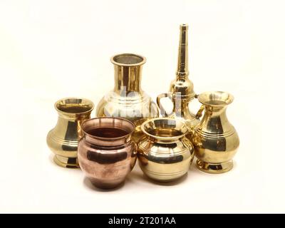 a collection of metal antique vase, pot and water vessel isolated in a white background Stock Photo