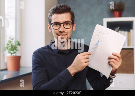Head shot portrait of young online tutor giving online lesson by video call, explaining exercise. Closeup. Webcam view. Distant learning, webinar, video class by teacher while coronavirus quarantine Stock Photo