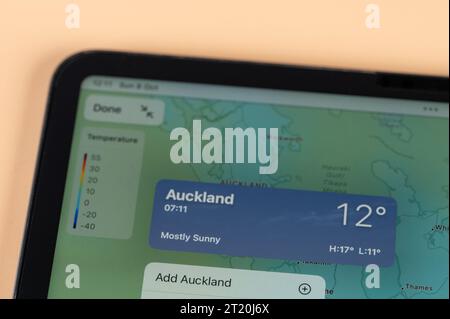 New York, USA - October 8, 2023: Checking temperature outside in Auckland city on online app ipad tablet screen close up view Stock Photo