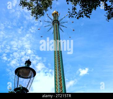 tower with chain carousel in the Viennese fairground Prater against blue sky and old street lamp in the foreground, Austria Stock Photo