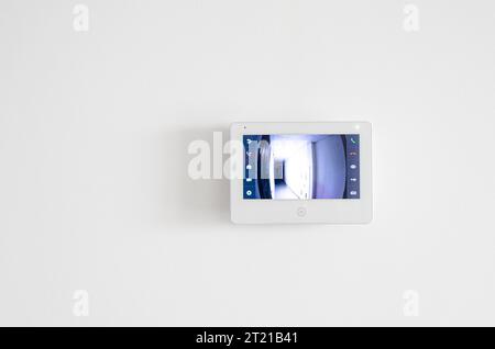 A white video intercom screen on a white apartment wall Stock Photo