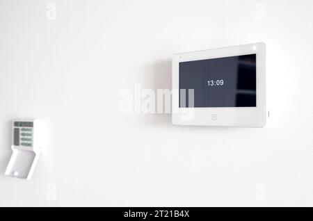 A white video intercom screen on a white apartment wall Stock Photo