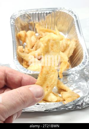 A closeup of fish in a tinfoil container on a white background Stock Photo