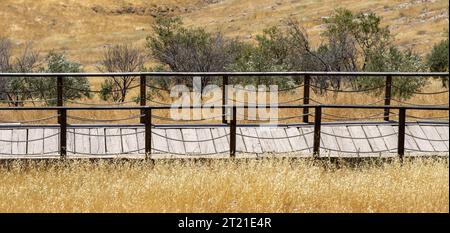 Wooden fence bridge over meadow and grass. Made of rope ropes. Sidewalk pathway Stock Photo