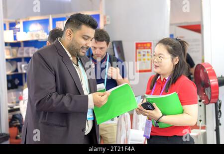 (231016) -- GUANGZHOU, Oct. 16, 2023 (Xinhua) -- A buyer from the United Arab Emirates visits a booth at the 134th session of the China Import and Export Fair in Guangzhou, south China's Guangdong Province, Oct. 15, 2023. The 134th session of the China Import and Export Fair, also known as the Canton Fair, has attracted exhibitors and buyers from across the globe. About 60 percent of the exhibitors attending the import exhibition are Belt and Road Initiative (BRI) partner countries, and the number of buyers from BRI partner countries has witnessed an increase of 11.2 percent compared with last Stock Photo