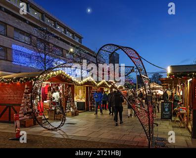 Christmas lights add a warmth to the little wooden stalls at Plymouth’s Christmas Market after sundown in 2021 Stock Photo