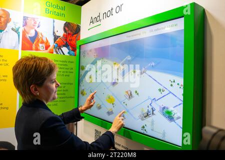 Aberdeen, Scotland, UK. 16th October 2023.  Day two of the SNP annual conference and former First Minister Nicola Sturgeon makes an appearance. A media frenzy followed before she made her way into the conference venue to listen to the afternoon’s proceedings. Nicola Sturgeon tries an interactive simulation by BP.  Iain Masterton/Alamy Live News Stock Photo