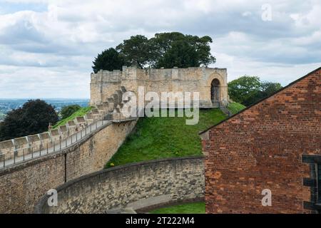 The circa 12th Century  'Lucy Tower' stands on one of the two mottes in Lincoln Castle, Lincolnshire, England.  The red brick gable end and stone wall Stock Photo
