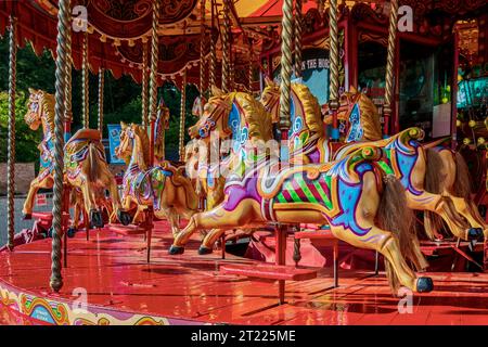 A prancers fairground ride of wooden horses awaiting riders. Stock Photo
